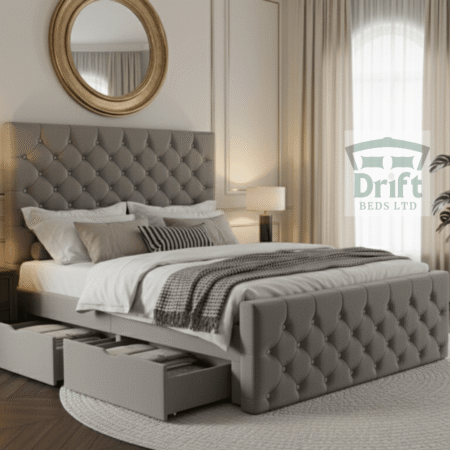 A side view of the elegant Chesterfield divan bed in grey, showcasing two smoothly gliding drawers pulled out from the base, perfect for organized storage.