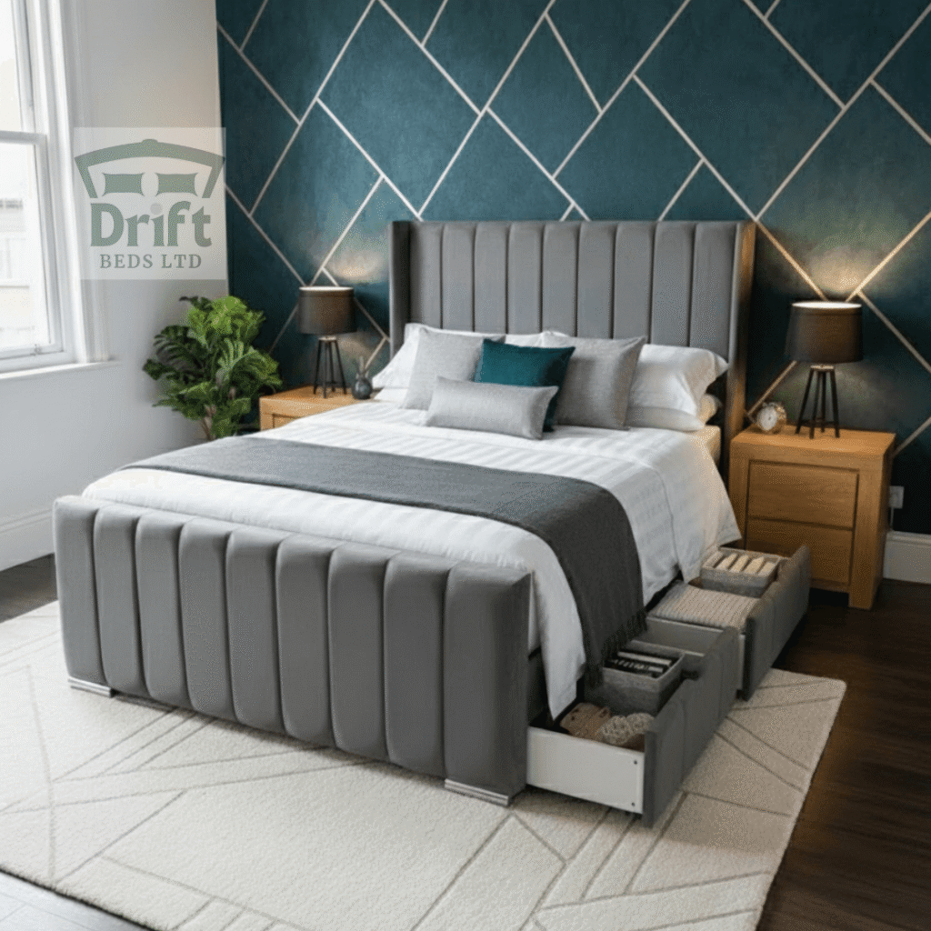 The Clarence Wingback Divan Bed Frame Vertical Fluted Panel Design The stately Clarence Wingback bed in grey, showcasing its tall, panelled frame and two convenient foot-end drawers pulled out for storage.