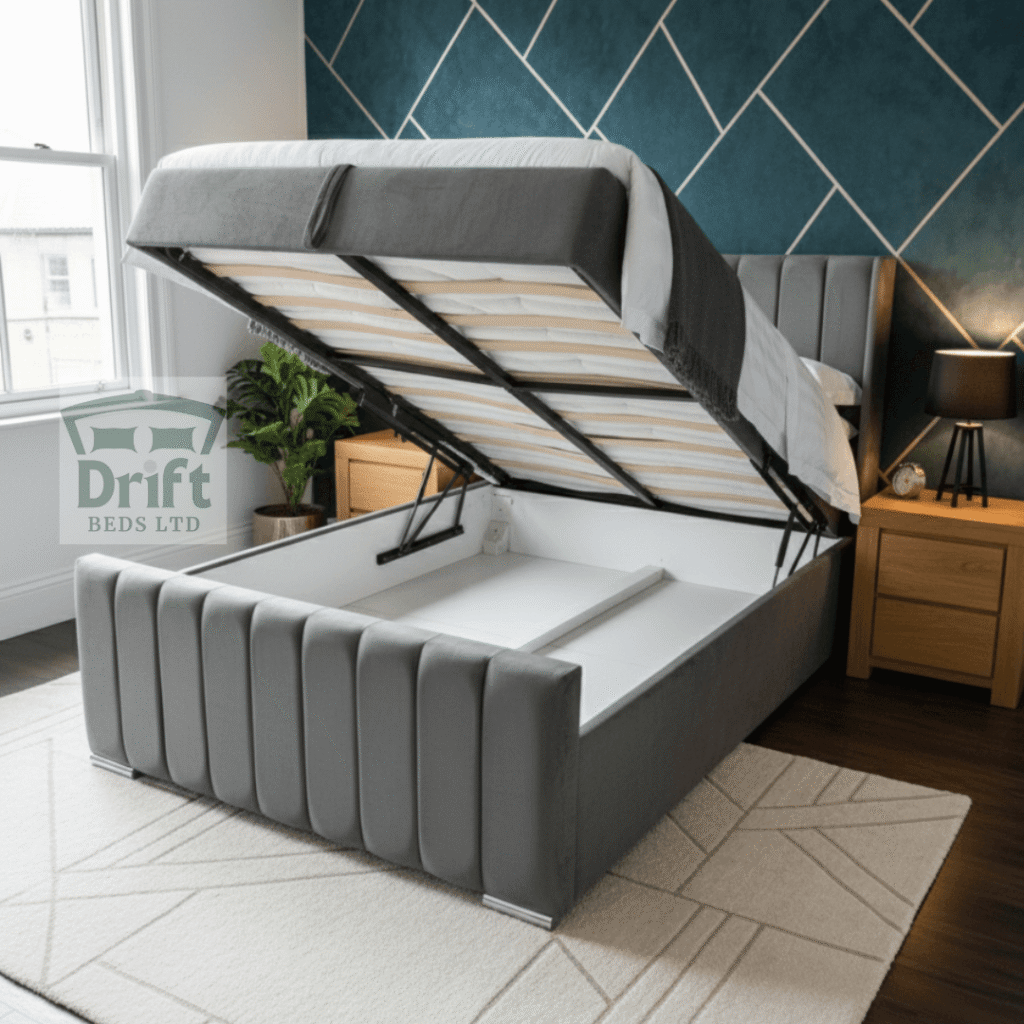 The grand Clarence Wingback ottoman bed in a sophisticated grey velvet, with its mattress lifted to reveal a deep and spacious internal storage area.
