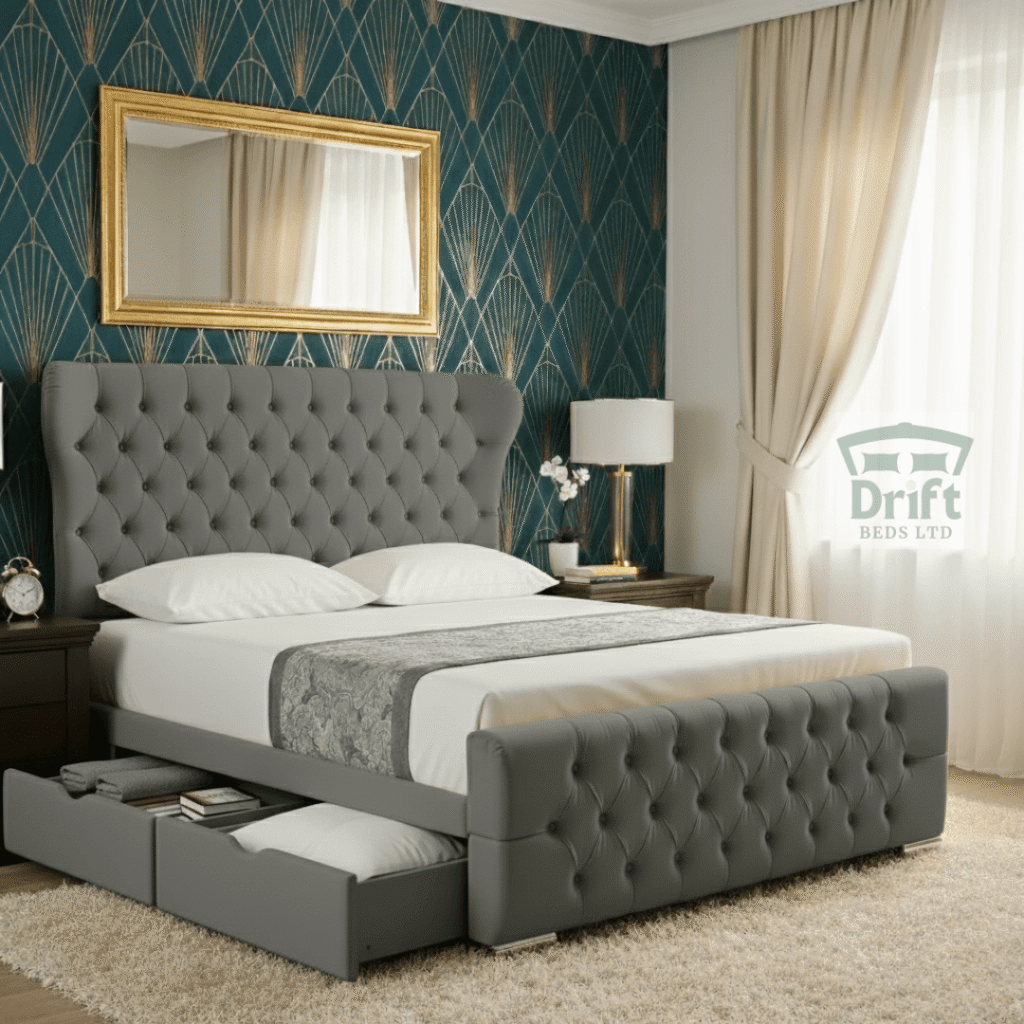 The stately Robin Wingback bed in grey, showing two large, convenient drawers pulled out from its deeply tufted foot end.