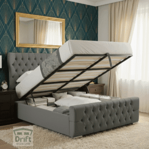The magnificent Robin Wingback ottoman bed in charcoal grey velvet, with its mattress lifted to reveal a vast, hidden storage area perfect for a luxury home.