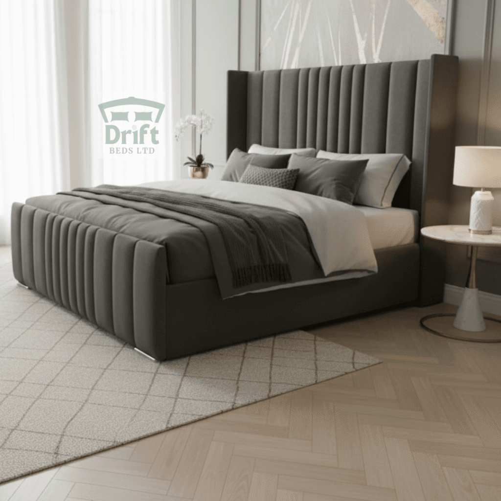 The Rome Wingback divan bed in a sleek grey velvet, highlighting its plush vertical panels and integrated side-drawer storage.