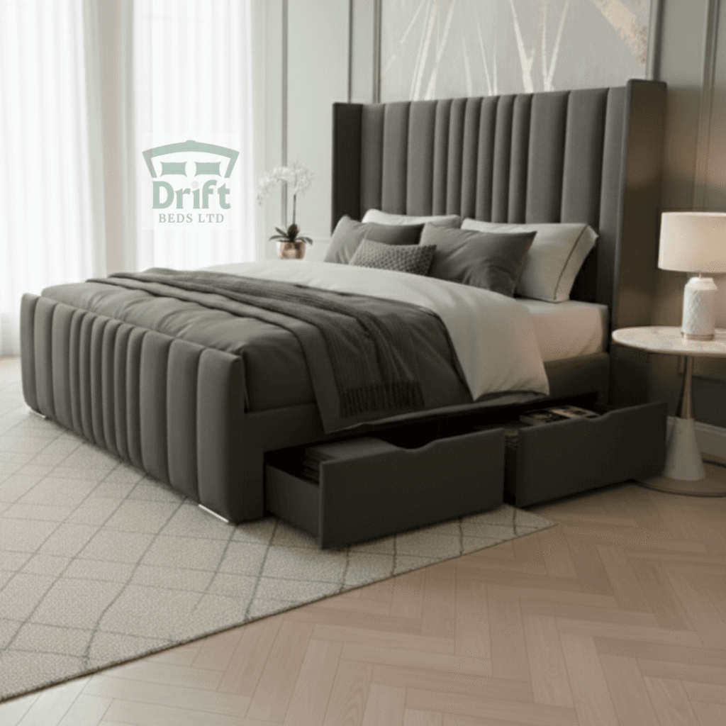 The stately Rome Wingback bed in charcoal grey, showcasing its tall, fluted headboard and two large, practical side drawers pulled out from the base.