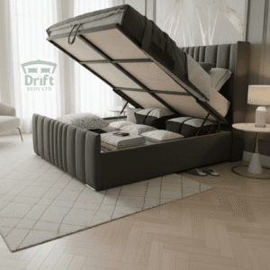 The majestic Rome Wingback ottoman bed in charcoal grey, with its mattress lifted to reveal a cavernous storage space concealed within its grand, panelled frame.